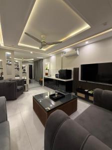 a living room with couches and a flat screen tv at Serenity Residence Room Studio 1BHK in Rachiāl