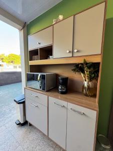 a cabinet with a microwave in a room at Casa Bri in Antiguo Cuscatlán