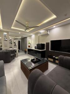 a living room with couches and a flat screen tv at Serenity Residence Room Studio 1BHK in Rachiāl