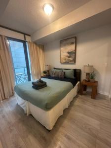 a bedroom with a bed and a large window at Functional Condo Sleep 6 in Port Hope
