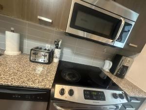 a kitchen with a stove and a microwave at Functional Condo Sleep 6 in Port Hope