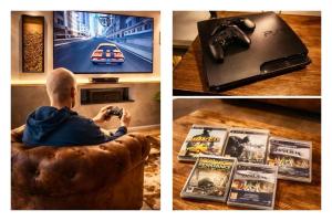 a man sitting on a couch taking a picture of a video game at Loft Prenium PETITE FRANCE-idéal mission Pro-long séjour in Strasbourg