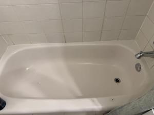 a white bath tub with a faucet in a bathroom at Small Apartment for 2 in St. Catharines