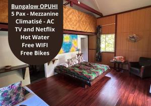 a room with a bed and a couch in it at Pension Hibiscus Taha'a in Vaitoare