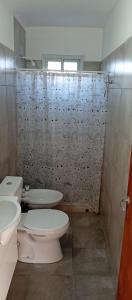 a bathroom with a toilet and a shower curtain at Casa Sol Naciente in Villa Santa Cruz del Lago +14 photos