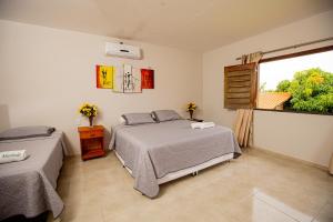 a bedroom with two beds and a window at Pousada Sítio Machado in Viçosa do Ceará +37 photos