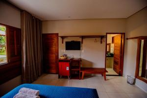 a living room with a desk and a television at Pousada Sítio Machado in Viçosa do Ceará