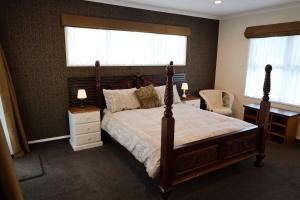 a bedroom with a large bed and two windows at Rev it up Homestay in Feilding +8 photos