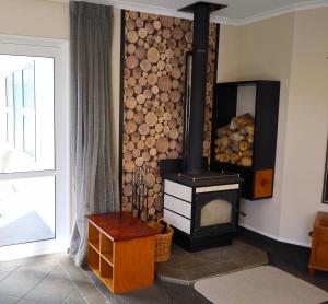 a living room with a wood stove next to a window at Rev it up Homestay in Feilding