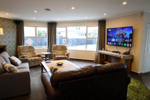 a living room with couches and a flat screen tv at Rev it up Homestay in Feilding