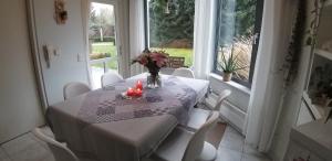a table with a vase of flowers and candles on it at logies Huis Liselotte in Genk