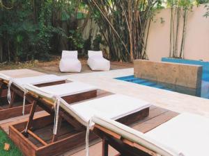 a patio with two beds and a pool at Quinta Nina Playa del Carmen - Solo Adultos in Playa del Carmen