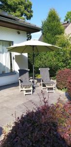 a group of chairs and an umbrella on a patio at logies Huis Liselotte in Genk +13 photos