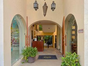 an alleyway with arches and potted plants in a building at Quinta Nina Playa del Carmen - Solo Adultos in Playa del Carmen