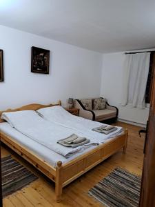 a bedroom with a bed and a couch in it at Дядо Цоньовата къща самостоятелен имот с басейн in Sevlievo +14 photos