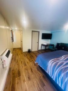 a bedroom with a bed and a wooden floor at Felton Motel in Breezewood