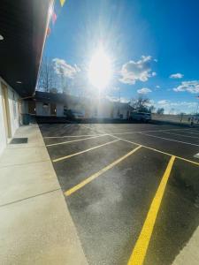 an empty parking lot with the sun in the sky at Felton Motel in Breezewood