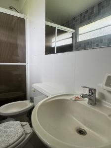 a white bathroom with a sink and a toilet at Paraiso Yapeyù in Yapeyú +8 photos
