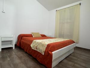 a white bedroom with a bed and a window at Paraiso Yapeyù in Yapeyú