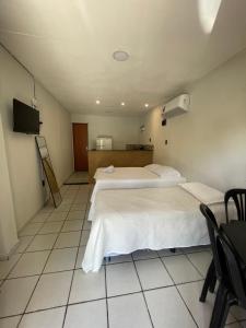 a hotel room with two beds and a television at Flat Praia do Pontal in Baía Formosa
