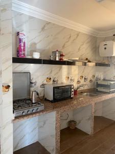 a kitchen with a stove and a microwave at Immeuble Elmo plage Mirleft in Mirleft