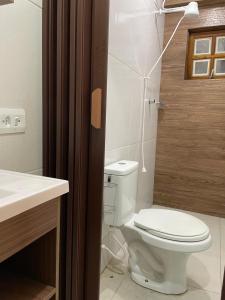 a bathroom with a toilet and a sink at Pousada NASCER DO SOL in Bertioga +12 photos