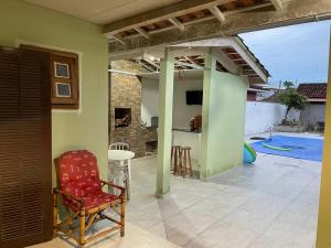a living room with a red chair and a patio at Pousada NASCER DO SOL in Bertioga