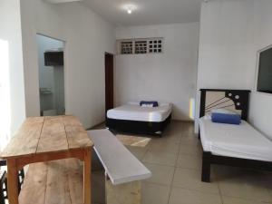 a room with two beds and a table and benches at Studio Apto Central próximo a Orla in Fatima do Sul