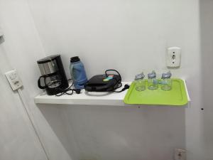 a shelf with glasses and a coffee maker on it at Studio Apto Central próximo a Orla in Fatima do Sul +13 photos