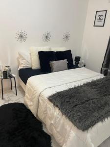 a bedroom with a large white bed with a black blanket at Modern Ocean View Apartment in Upper Prince's Quarter