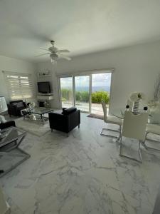 a living room with a couch and a table and chairs at Modern Ocean View Apartment in Upper Prince's Quarter