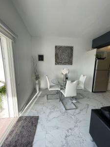a living room with a table and a refrigerator at Modern Ocean View Apartment in Upper Prince's Quarter +6 photos