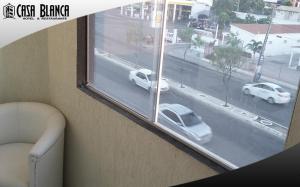 a window with a view of a street with cars at Hotel Casa Blanca in Mossoró