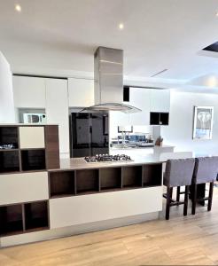 a kitchen with white cabinets and a kitchen island with chairs at Departamento Andares in Guadalajara