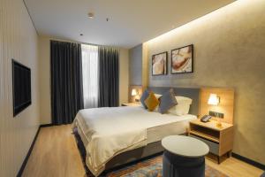 a hotel room with a bed and a television at The Canvas Loft-Manyata Tech Park-Orchid Parc in Bangalore +60 photos