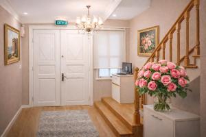 a hallway with a vase filled with pink roses at valide-maide hotel in Istanbul