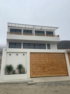 a house with a large wooden garage door at Casa Apartment Playa Tortugas in Tortuga