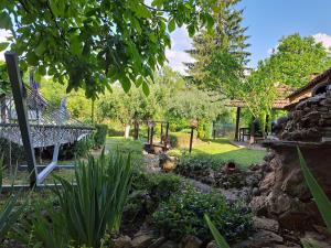 a garden with a stone wall and a fence at Дядо Цоньовата къща самостоятелен имот с басейн in Sevlievo