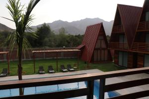 a view of a resort with a pool and mountains at Alpinas Natural Suites in Lunahuaná