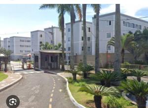 a street in front of a building with palm trees at Apto 2 quartos, Wi-Fi rápido, Self check in in Uberlândia