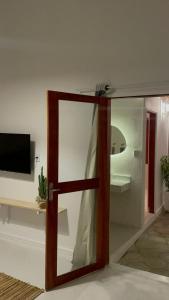 a glass door in a living room with a television at Casa Carnaubas in Icapuí +22 photos