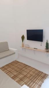 a living room with a tv on a white wall at Casa Carnaubas in Icapuí