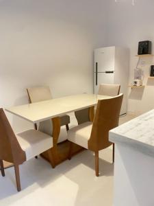 a kitchen with a table and chairs and a refrigerator at Casa Carnaubas in Icapuí