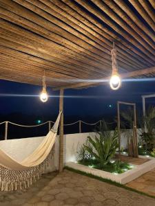 a hammock on a patio at night with lights at Casa Carnaubas in Icapuí