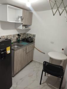 a small kitchen with a table and a black refrigerator at El Hogar de Ami in Cali