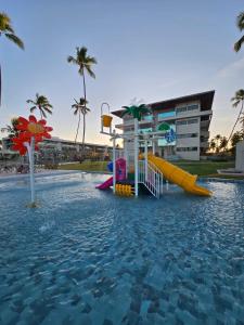 a pool of water with a water park with slides at Apartamento Ipioca Beach Life in Ipioca