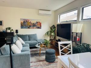 a living room with a blue couch and a flat screen tv at Quiet and Cozy corner in Braybrook