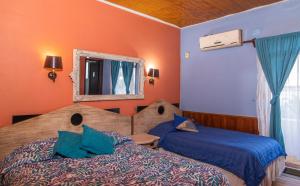 a bedroom with two beds and a mirror at Hotel La Castellana in Santiago
