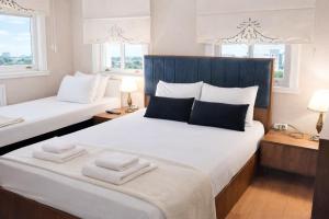 two beds in a room with two windows and two towels at valide-maide hotel in Istanbul