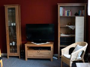 a living room with a television on a wooden entertainment center at Brocken-Blick in Hüttenrode